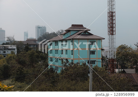 A vibrant urban landscape featuring a colorful building alongside a prominent communication tower A vibrant urban landscape featuring a colorful building alongside a prominent communication tower 128956999