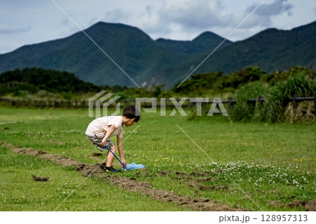 ＜素材＞芝生の公園で虫取りをする男の子 128957313