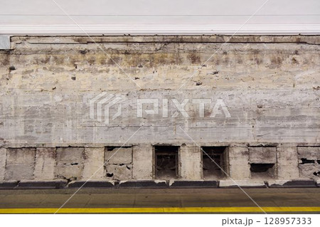 The Urban Texture of a Weathered Concrete Wall Featuring Openings and Distinct Elements 128957333
