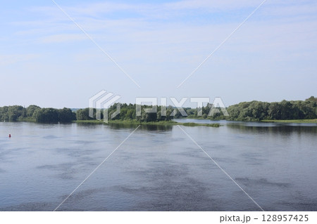 The Serene and Tranquil River Landscape Under a Clear and Vibrant Blue Sky Above 128957425