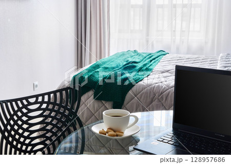 A Cozy and Inviting Workspace with a Warm Cup of Coffee and Soft Blanket in a Bright Room A Cozy and Inviting Workspace with a Warm Cup of Coffee and Soft Blanket in a Bright Room 128957686