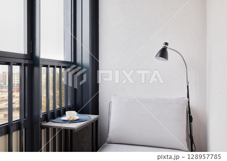 A Cozy Modern Corner Featuring Abundant Natural Light and Elegant Minimalist Decor 128957785