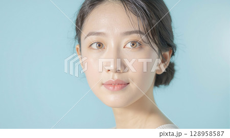 水色背景にナチュラルメイクの中年女性 水色背景にナチュラルメイクの中年女性 128958587