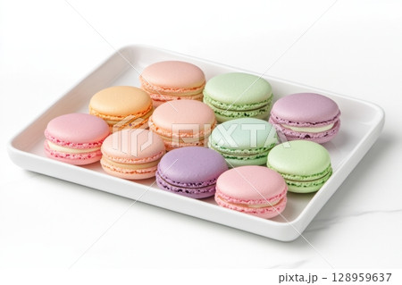 Pastel macarons in shades of lavender, pink, and mint green are beautifully arranged on a white plate, showcasing their delightful colors and appealing textures for a festive occasion. 128959637