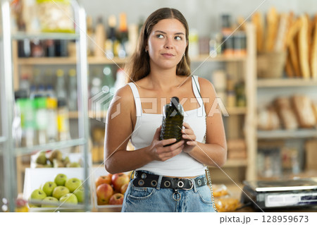 Young woman choosing olive oil in grocery store Young woman choosing olive oil in grocery store 128959673