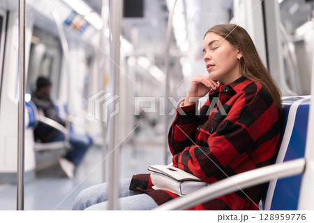 Girl sit and doze in tram car, getting to work Girl sit and doze in tram car, getting to work 128959776