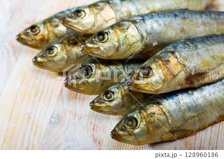 Pickled pilchards on wooden background with copyspace Pickled pilchards on wooden background with copyspace 128960186