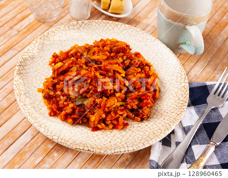 Stewed cabbage with pearl barley on wooden table 128960465