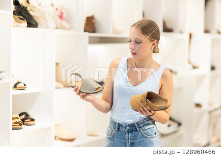 Young woman choosing shoes in a store 128960466