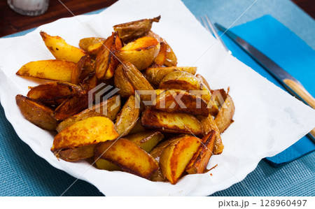 Tasty cooked baked in oven salted potatoes served at plate 128960497