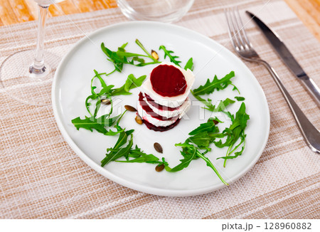beets with goat cheese and arugula on white plate beets with goat cheese and arugula on white plate 128960882