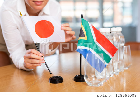 Blurry girl set midget flags of South Africa and Japan before international negotiations Blurry girl set midget flags of South Africa and Japan before international negotiations 128961088