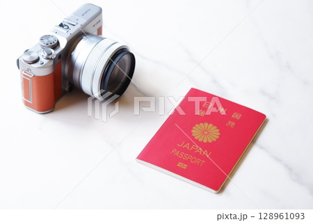 パスポート - パスポート（一般旅券10年用赤色）とカメラを用意して、海外旅行を計画しているイメージ 128961093