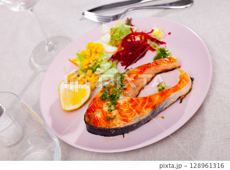 Fried salmon steak with a light vegetable salad Fried salmon steak with a light vegetable salad 128961316
