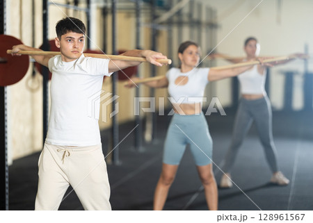 Young guy doing warm-up with stick 128961567