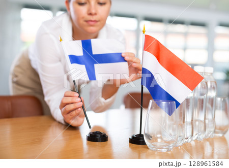 Blurry girl set midget flags of Netherlands and Finland before international negotiations Blurry girl set midget flags of Netherlands and Finland before international negotiations 128961584
