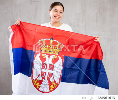 Portrait of positive young woman with flag of Serbia 128961613