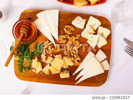 Cheese board served with honey over white background Cheese board served with honey over white background 128961827