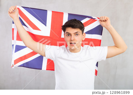 Male football fan holding Great Britain flag Male football fan holding Great Britain flag 128961899