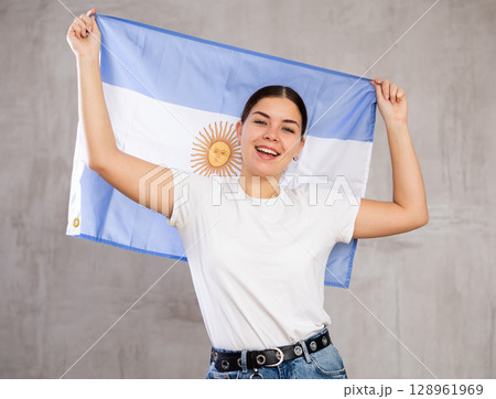 Happy girl stands with flag of Argentina .Isolated 128961969