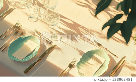 Pastel-colored place cards and delicate cutlery on a neutral-toned tablecloth . 128962481