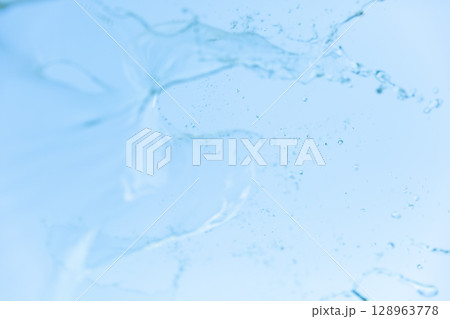 青空をバックに広がる水しぶき 流形を描いて落ちる透明な水のしずく 128963778