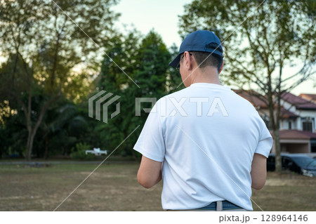 Man operating drone in the field Man operating drone in the field 128964146