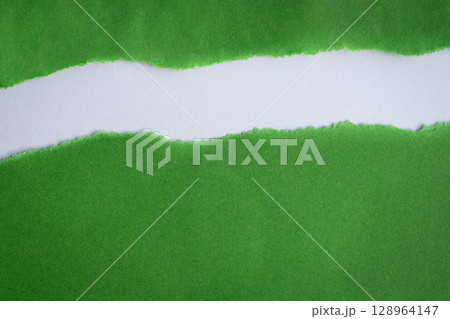 Torn green paper into half on top of white background Torn green paper into half on top of white background 128964147