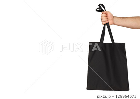 A person lifts a comfy black tote bag, isolated on white, PNG A person lifts a comfy black tote bag, isolated on white, PNG 128964673