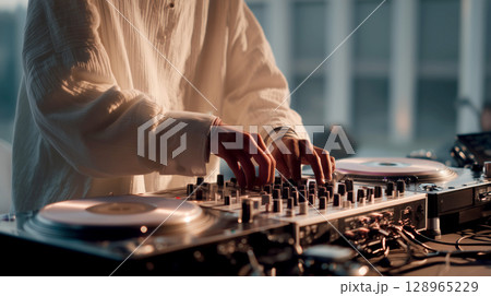 DJ in white shirt skillfully mixes music on professional DJ controller at event DJ in white shirt skillfully mixes music on professional DJ controller at event 128965229