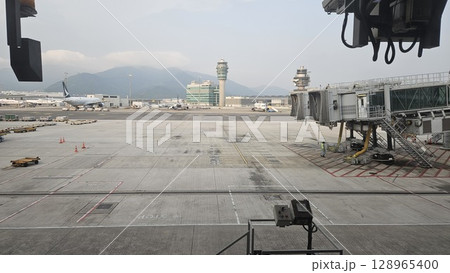 Hong Kong, China - 12th July 2025 - This is Hong Kong airport with ATC tower and a Cathay Pacific aeroplane. 128965400
