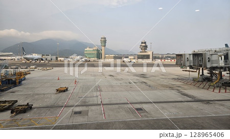 Hong Kong, China - 12th July 2025 - This is Hong Kong airport with ATC tower and a Cathay Pacific aeroplane. Hong Kong, China - 12th July 2025 - This is Hong Kong airport with ATC tower and a Cathay Pacific aeroplane. 128965406