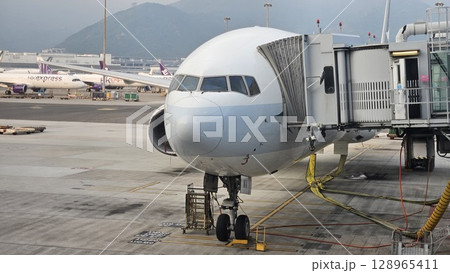 Hong Kong, China - 12th July 2025 - This is Hong Kong airport with ATC tower and a Cathay Pacific aeroplane. 128965411