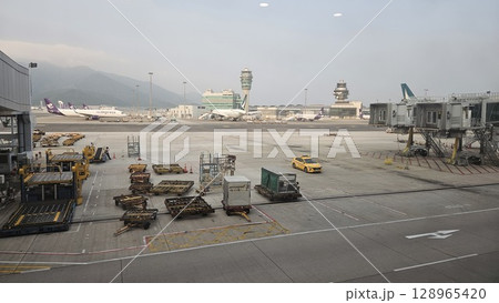 Hong Kong, China - 12th July 2025 - This is Hong Kong airport with ATC tower and a Cathay Pacific aeroplane. Hong Kong, China - 12th July 2025 - This is Hong Kong airport with ATC tower and a Cathay Pacific aeroplane. 128965420
