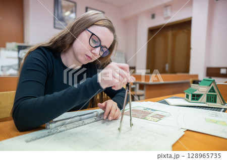 Caucasian young woman making drawings. Student of architecture university. Caucasian young woman making drawings. Student of architecture university. 128965735