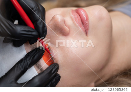 Caucasian woman undergoing eyelash lamination procedure. Caucasian woman undergoing eyelash lamination procedure. 128965865