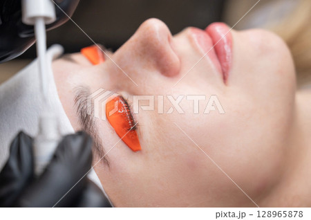 Caucasian woman undergoing eyelash lamination procedure.  128965878