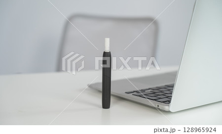 Tobacco heating system next to a laptop.  128965924