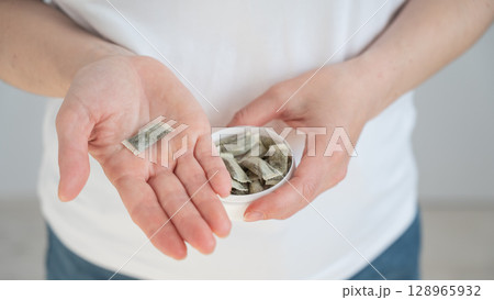 A woman holds a jar of chewing tobacco. A woman holds a jar of chewing tobacco. 128965932