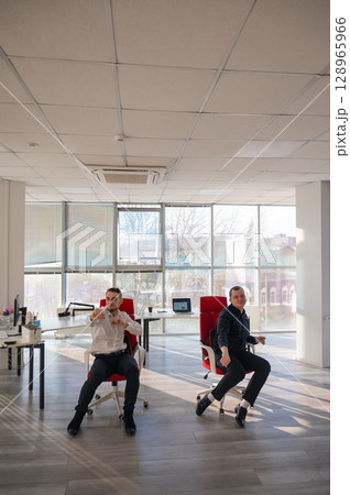 Two Caucasian men having fun at work. Two Caucasian men having fun at work. 128965966