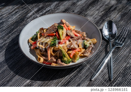 Pasta with beef, mushrooms and vegetables.  128966181