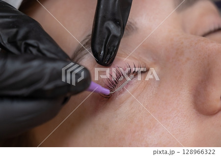 The process of professional eyelash lamination in a salon. The process of professional eyelash lamination in a salon. 128966322