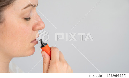 Caucasian woman smoking disposable vape.  128966435