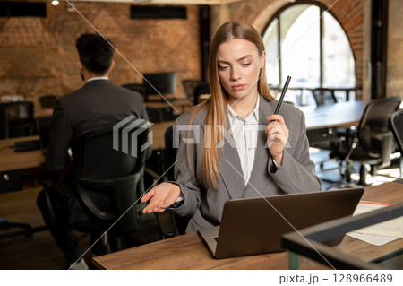 Cute long-haired blonde female manager working in the office 128966489