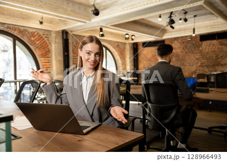 Two young professionals working in the office together 128966493
