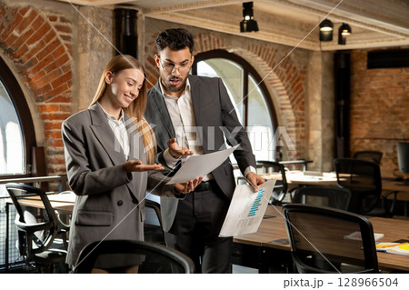 Two young professionals working in the office together 128966504