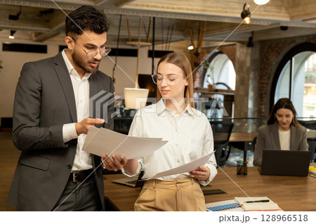 Two young professionals working in the office and looking involved Two young professionals working in the office and looking involved 128966518