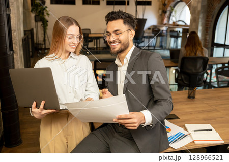 Two young professionals working in the office and looking involved 128966521