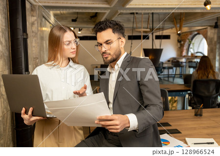 Two young professionals working in the office and looking involved Two young professionals working in the office and looking involved 128966524