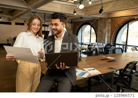 Colleagues in the office discussing project details and looking involved 128966571